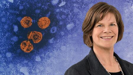 Portrait picture of Prof. Ulrike Protzer in front of an electron microscope image of hepatitis B virions.of. Ulrike Protzer vor einer elektronenmikroskopischen Aufnahme von Hepatitis-B-Virionen