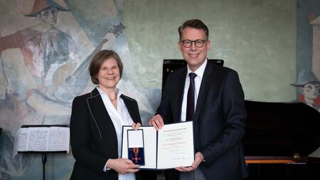 The picture shows Markus Blume, Minister of Science and the Arts (right), presenting Professor Dr. Ulrike Protzer with the Federal Cross of Merit.