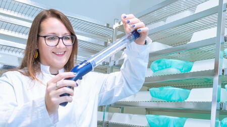 Victoria Ingham in the lab holding a suction flask full of Anopheles mosquitoes.