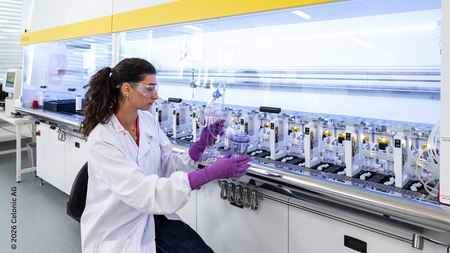 Scientist working with an automated bioreactor system in a biotechnology laboratory.