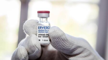Eine behandschuhte Hand hält ein Impfstofffläschchen mit der Beschriftung "Ervebo_solution for injection_rVSVΔG-ZEBOV-GP_live_1 dose"