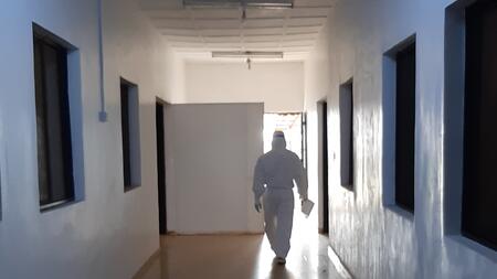 Person in protective gear walking along a hallway