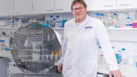 Prof. Stephan Urban im Labor; links im Bild ist die Trophäe des Chris McGuigan-Preises zu sehen.