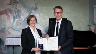 The picture shows Markus Blume, Minister of Science and the Arts (right), presenting Professor Dr. Ulrike Protzer-Knolle with the Federal Cross of Merit.