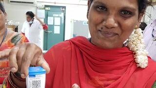 Eine indische Labormitarbeiterin hält die in der Studie getestete Testkartusche in der rechten Hand.