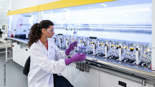 Scientist working with an automated bioreactor system in a biotechnology laboratory.