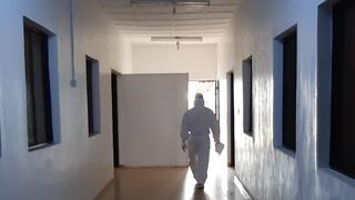 Person in protective gear walking along a hallway