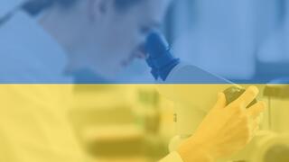 Ukrainische Flaggenfarben, im Hintergrund ist eine Forscherin am Mikroskop zu sehen.