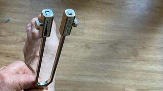 A tuning fork is struck in contact with a foot to test sensitivity in the diagnosis of neuropathy.