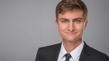 Portrait of Dr. Janko Sattler. Mr Sattler is wearing a dark suit and tie.