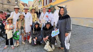 Group of adults and children in malaria- and mosquito-themed costumes at the Tübingen Regional Market.